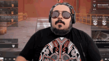 a man wearing sunglasses and headphones is playing a game called modern warfare