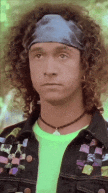 a man with curly hair is wearing a headband and a neon green shirt