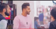 a group of men are standing next to each other in a room talking .