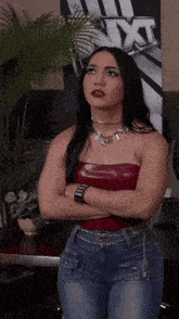 a woman standing in front of a nxt poster