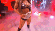 a woman in a bikini is dancing on a stage in front of a live audience .