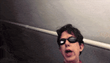 a man wearing sunglasses is making a face
