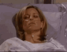 a woman is laying in a hospital bed wearing an oxygen mask .