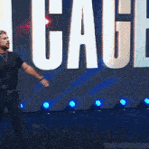 a man is standing in front of a large sign that says cage .