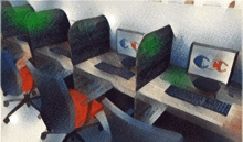 a row of cubicles with cc written on the monitors