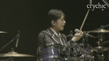 a woman playing drums with the word crychic in the corner