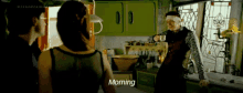 a man is pouring a cup of coffee into a woman 's cup in a kitchen and the woman says morning .