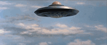 a flying saucer with a blue light coming out of it 's mouth