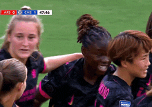 a group of female soccer players are huddled together on a field with a scoreboard that says che 1 at the top