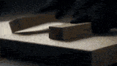 a person is cutting a piece of wood on a table with a saw .