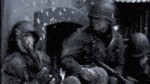 a group of soldiers are sitting in front of a building holding guns