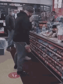 a man wearing a mask is standing in front of a counter in a store
