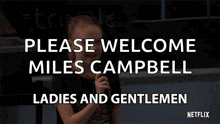 a little girl is holding a microphone in front of a blackboard and saying please welcome miles campbell ladies and gentlemen