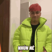 a man with red hair is wearing a neon green jacket and giving a thumbs up .