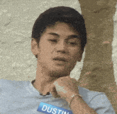 a young man wearing a name tag that says dustin on it