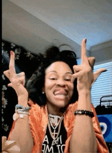 a woman wearing a t-shirt that says " a.m.i.c. " is making a funny face