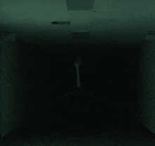 a man in a suit is standing in a dark hallway .