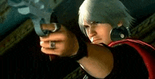 a man in a red cape is holding a gun in his hand .