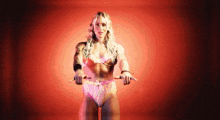 a woman in a bikini is standing in front of a red background and holding a pair of scissors .