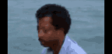 a man in a white shirt is sitting in the water .