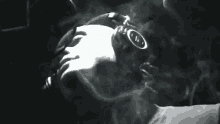 a man is smoking a cigarette in a dark room .
