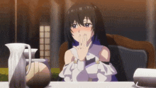 a girl with long black hair is sitting at a table with a pitcher of coffee and a pitcher of water