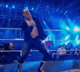 a man in a suit is dancing in a wrestling ring with the word yee behind him