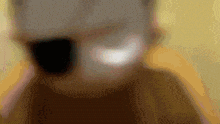a blurred image of a person 's face with a yellow background
