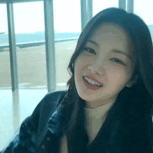 a woman with long hair is smiling and wearing a fur coat