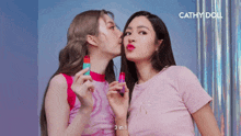 two women are kissing each other with the words cathy doll behind them