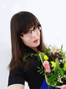 a woman with glasses holds a bouquet of flowers