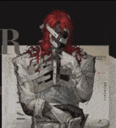 a man with red hair is wearing a skeleton costume and a mask .