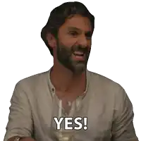 a man with a beard is holding a wine glass and saying yes