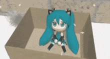 hatsune miku is sitting in a cardboard box on the ground .
