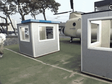 a helicopter is parked in front of a building with the number 1 on the top right
