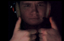 a man wearing a helmet giving a thumbs up sign