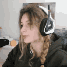 a woman wearing headphones and a braided hair looks to the side
