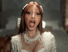 a woman in a white dress with pearls around her neck