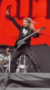 a woman playing a guitar on a stage in front of a sign that says ' nirvana ' on it