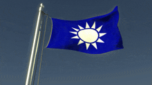 a blue flag with a white sun on it is flying in the wind