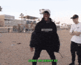 a man in a black hoodie says come on kenny x2 on the beach