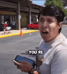 a man is holding a cell phone with the words you 're on it