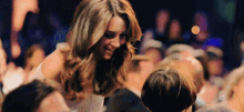a woman is talking to a man in a crowd at a concert .