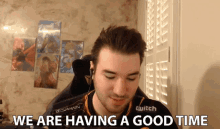a man in a twitch shirt says we are having a good time while sitting in a chair
