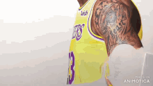 a man with a tattoo on his arm is wearing a yellow jersey with the number 13 on it