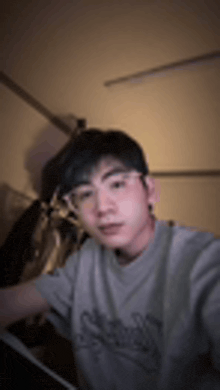 a young man wearing glasses is taking a selfie .