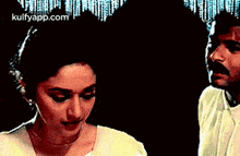 a man and a woman are standing next to each other in a room .