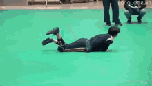 a person is laying on the floor with a rope around their neck .