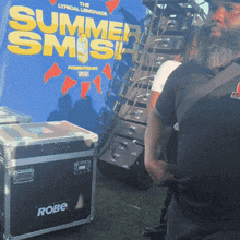 a man stands in front of a summer smash sign
