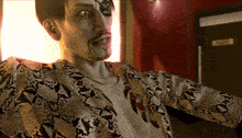 a man in a snakeskin jacket has a tattoo on his chest